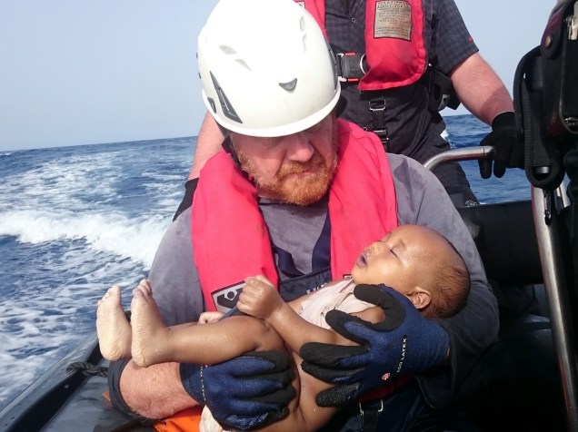 Imagem divulgada em 30 de maio, mostra um socorrista alemão da organização humanitária Sea-Watch com o corpo de um bebê imigrante afogado, resgatado após naufrágio na costa da Líbia - 27/05/2016