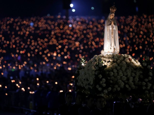 Imagem de Nossa Senhora de Fátima é conduzida por fiéis católicos durante vigília à luz de velas, no 99º aniversário da aparição da Virgem Maria aos três pastorinhos, no santuário de Fátima, em Portugal