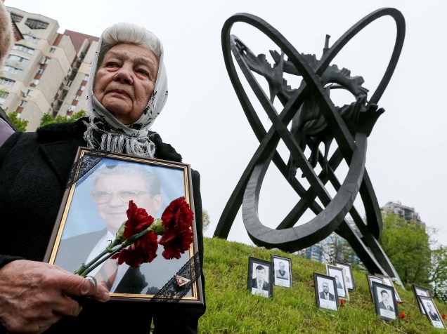Uma mulher sobrevivente do desastre de Chernobyl leva flores em homenagem às vítimas durante cerimônia memorial marcando os 30 anos do acidente nuclear, em Minsk, Belarus - 26/04/2016