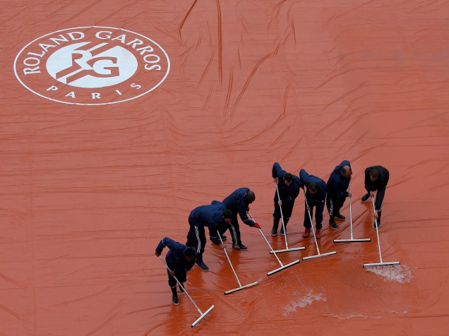 Equipe trabalha para retirar a água da chuva sobre a quadra antes do início da rodada do aberto de tênis da França, em Roland Garros - 31/05/2016