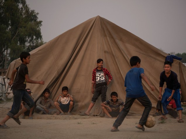 Crianças jogam bola em acampamento improvisado há um ano, para abrigar as vítimas do terremoto em Kathmandu, no Nepal, registrado com o maior que atingiu o país, deixando milhares de mortos - 25/04/2016
