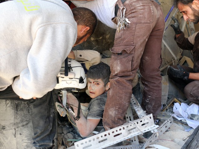 Voluntários resgatam vítimas de escombros depois de ataque aéreo do governo sírio na cidade de Aleppo, na Síria - 30/05/2016