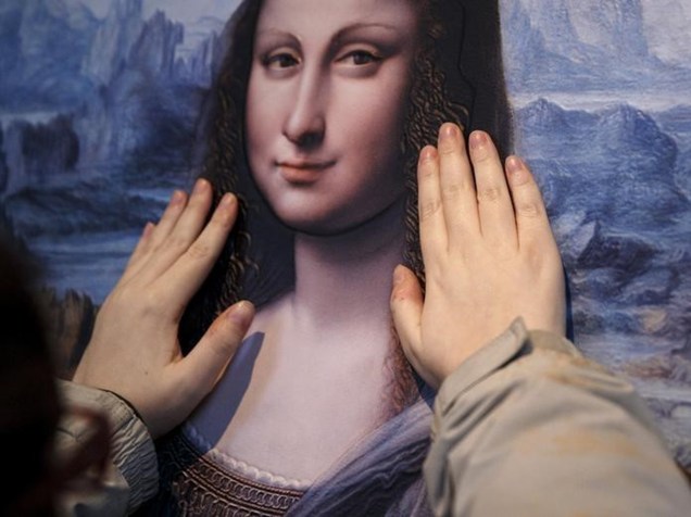 Visitante do Museu do Prado, em Madri, toca cópia da obra Mona Lisa, descoberta em 2012 e restaurada por especialistas  - 25/04/2016
