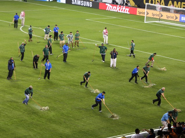 Funcionários tentam tirar água do campo de futebol, onde Chile e Colômbia disputaram vaga pela final da Copa América - 23/06/2016