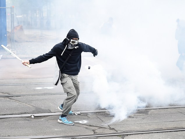 Manifestante atira projétil de volta para a polícia durante protestos contra a reforma trabalhista proposta pelo governo Francês - 02/06/2016