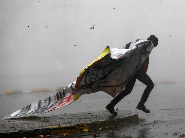 Manifestante foge de nuvem formada por bomba de gás lacrimogêneo, em protesto a favor de melhorias no sistema educacional, em Santiago, Chile - 05/05/2016
