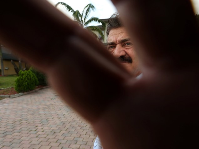 Pai do atirador que matou 49 pessoas na boate Pulse, em Orlando, Seddique Mateen, tenta segurar a lente do fotógrafo, em frente à sua casa em Sanit Port Lucie, na Florida - 14/06/2016