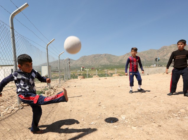 Garotos iraquianos, pertencentes ao grupo Yazidi, jogam futebol nos arredores da província de Duhok