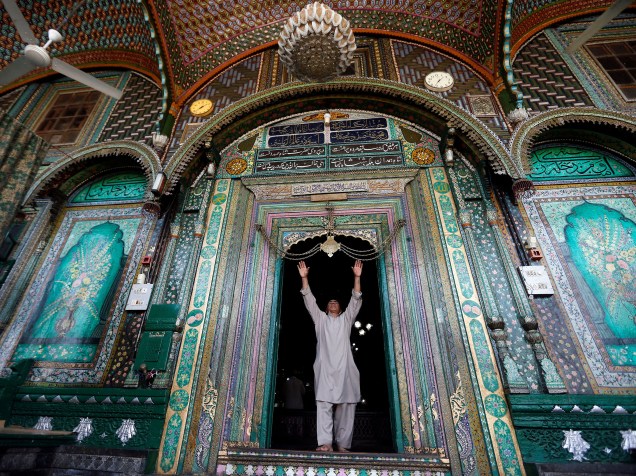 Homem toca um ornamento gravado com versos do Corão no santuário de Mir Syed Ali Hamdani, um santo sufi, durante o Ramadã, em Srinagar, na Índia - 14/06/2016