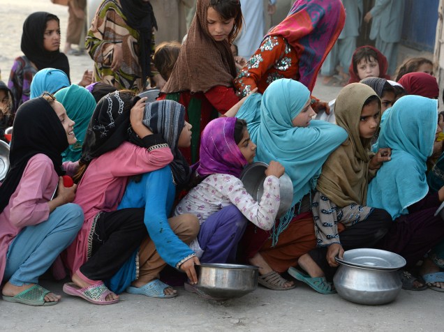 Garotas afegãs seguram recipientes e aguardam em fila para receberem comida de uma instituição privada de caridade, durante o período do Ramadan, mês em que muçulmanos praticam jejum - 10/06/2016