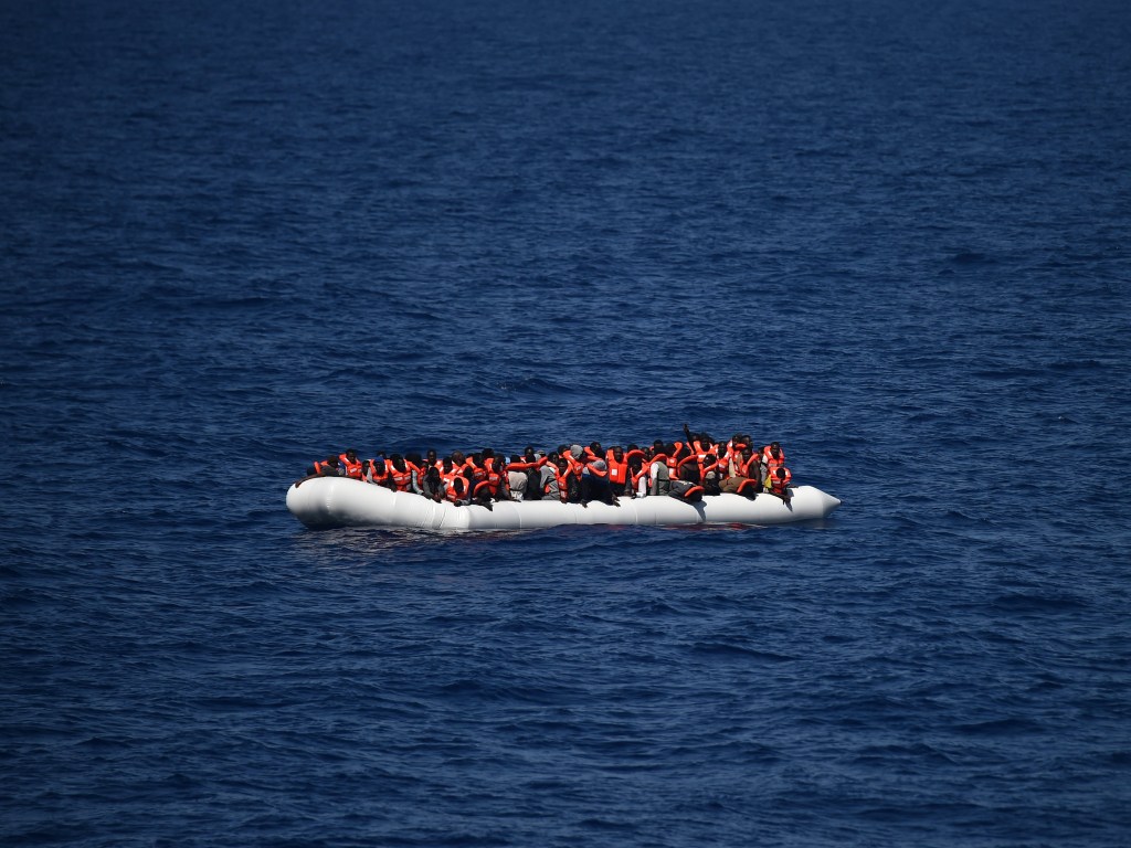 Refugiados aguardam resgate em um bote no Mar Mediterrâneo, em uma região perto da costa marítima da Líbia