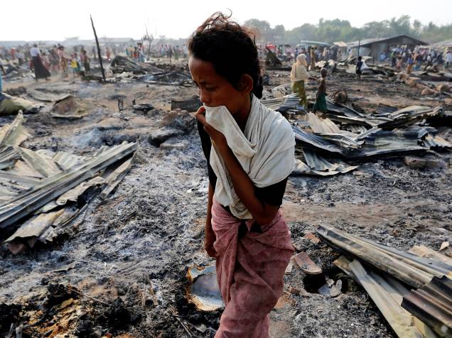 Mulher caminha por escombros deixados por incêndio, que destruiu parte de um acampamento muçulmano, no estado de Rakhine, no Mianmar - 03/05/2016