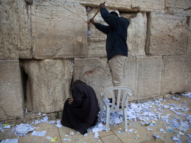 Funcionários removem mensagens e orações, escritos em pedaços de papel por milhares de pessoas "dirigida a Deus" no Muro das Lamentações, na Cidade Velha de Jerusalém, em preparação para o feriado da Páscoa judaica