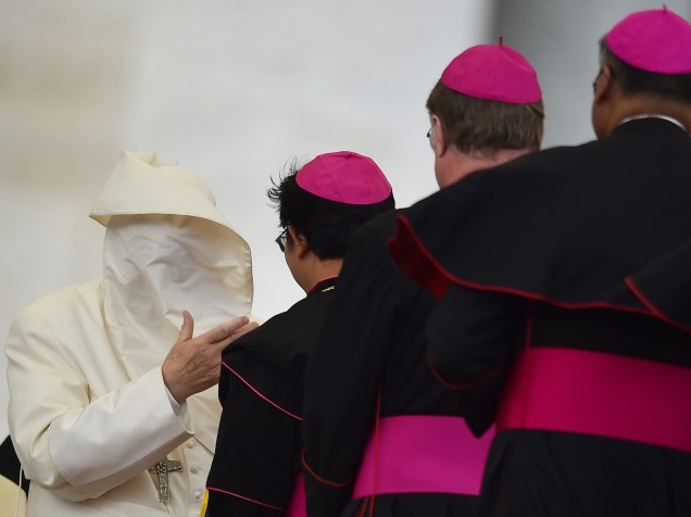 Rajada de vento deixa o Papa Francisco com o rosto coberto enquanto saúda cardeais e bispos, no final de sua audiência semanal na praça de São Pedro, no Vaticano - 13/04/2016