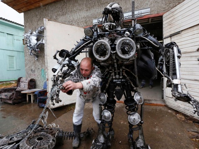 O mecânico e soldador russo Sergei Kulangin constroi um robô com peças de carros, na Sibéria