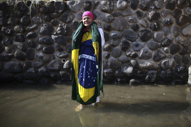 Uma cristã brasileira se batiza nas águas do Rio Jordão, na Galiléia, nesta quarta-feira (15)