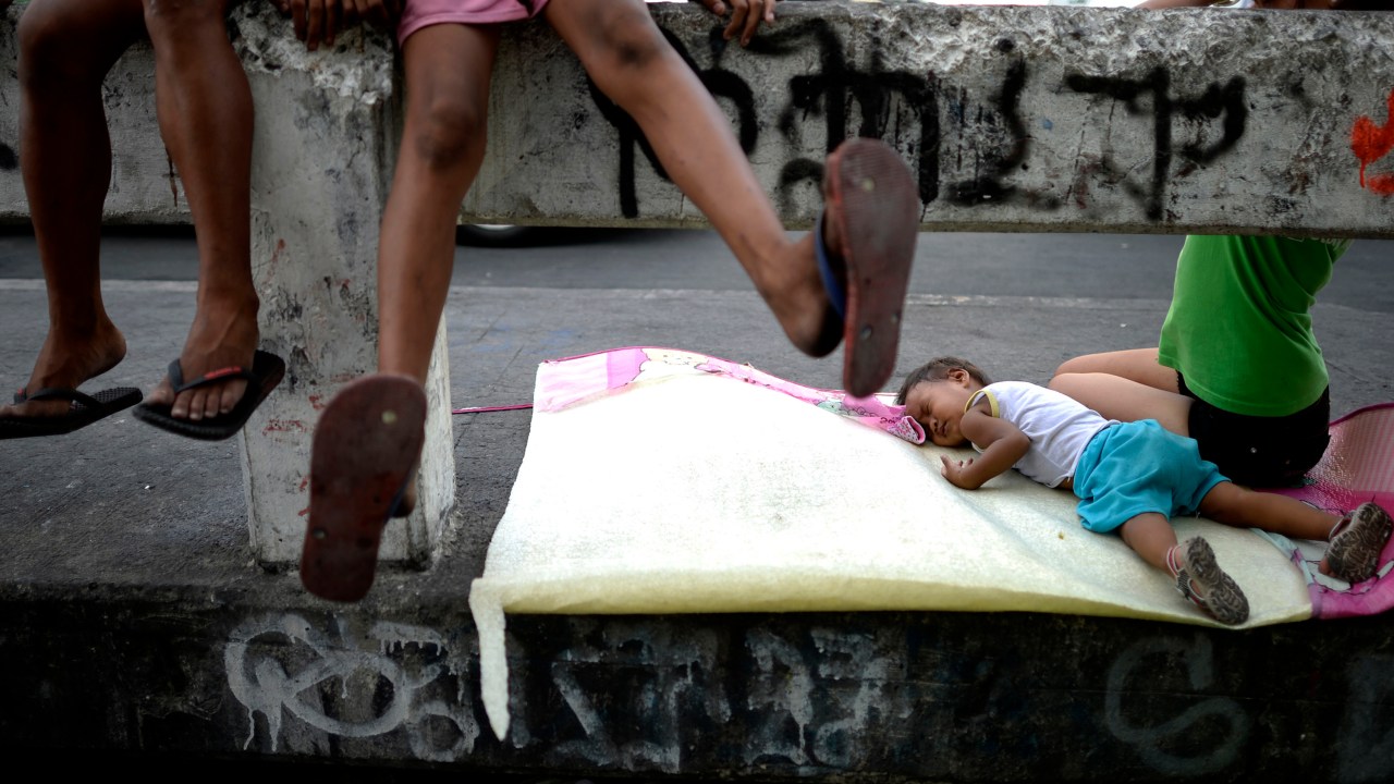 Criança dorme em ponte em Manila, nas Filipinas