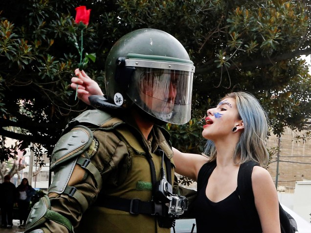 Estudante segura uma rosa e grita palavras de ordem, na frente de um policial, durante protesto contra reformas educacionais, na cidade de Valparaíso, no Chile - 26/05/2016