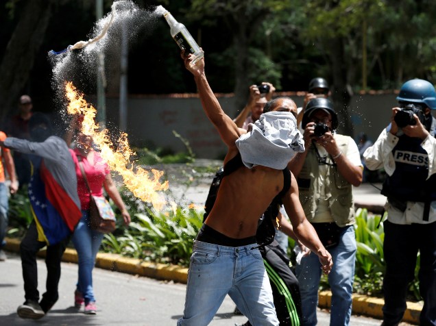Estudante arremessa coquetel molotov em direção a polícia venezuelana, durante protestos contra o governo, em Caracas, capital da Venezuela - 09/06/2016