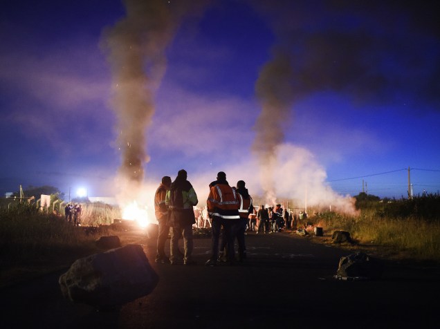 Trabalhadores bloqueiam acesso a um depósito de petróleo nos arredores de uma refinaria em Donges, oeste da França, em protesto contra as reformas da legislação trabalhistas propostas pelo governo - 27/05/2016