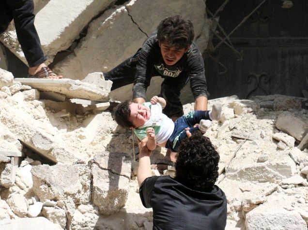 Bebê é resgatado após bombardeio do governo sírio em hospital de Aleppo, na região norte do país controlada por rebeldes. Pelo menos 27 pessoas morreram, entre elas o último pediatra da unidade - 28/04/2016