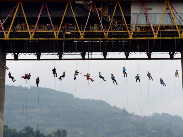 Pessoas escorregam por corda de uma ponte durante um treinamento de resgate na cidade de Chongqing, na China - 23/05/2016