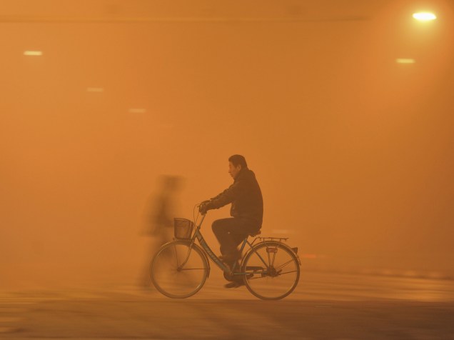 Homem andou de bicicleta sob forte neblina em Fuyang, na China. A névoa causada pela poluição atingiu diversas partes do norte e do leste da China