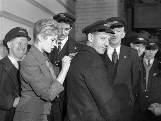 Trabalhadores ganham autógrafo da atriz francesa e símbolo sexual Brigitte Bardot, em Londres, em novembro de 1956