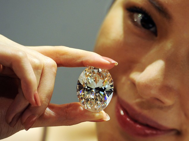Modelo segura diamante branco oval de 118.28 quilates durante a prévia da loja Sothebys em Honk Kong, 2013