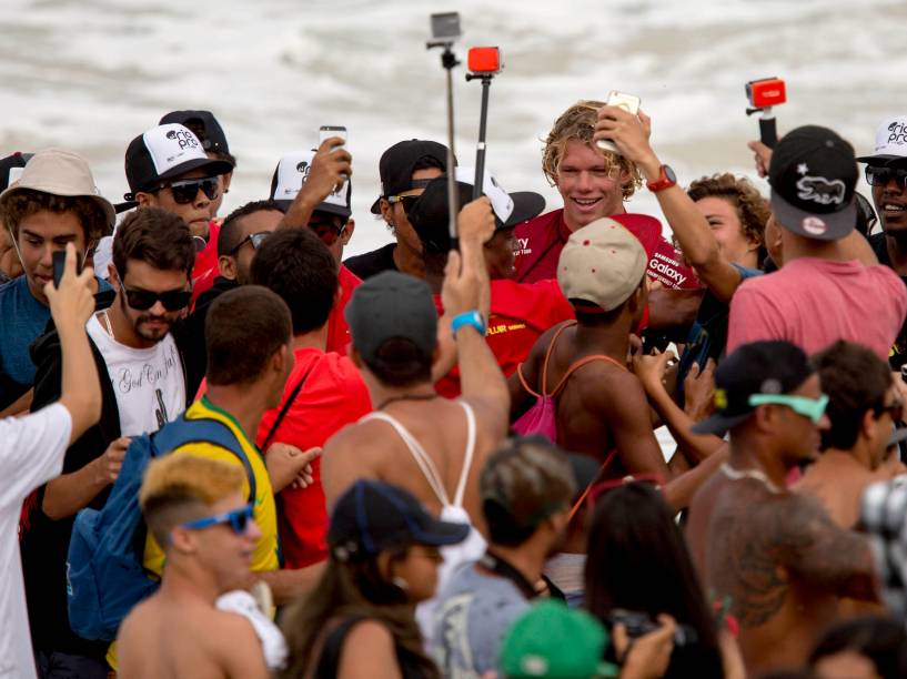 O havaiano John John Florence é recepcionado por fãs na praia após etapa de repescagem do Rio Pro 2015