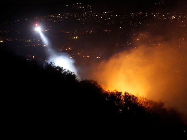 Helicópteros fazem patrulha em área tomada pelos incêndios na região de Calabasas, Califórnia