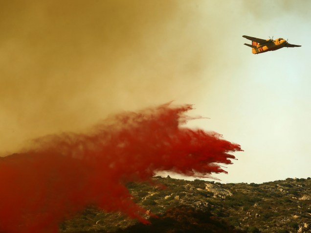 Avião despeja substância retardadora de fogo, para tentar conter os estragos causados pelos incêndios que atingem a região de Campo, na Califórnia