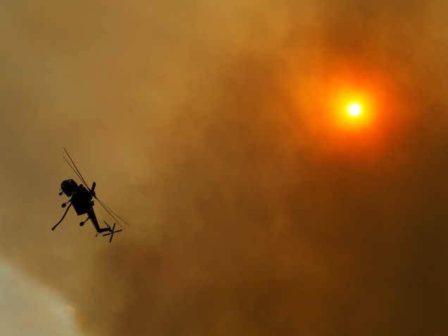 Helicópteros supervisionam trabalho de bombeiros que tentam conter o fogo na região próximo a Campo, na Califórnia