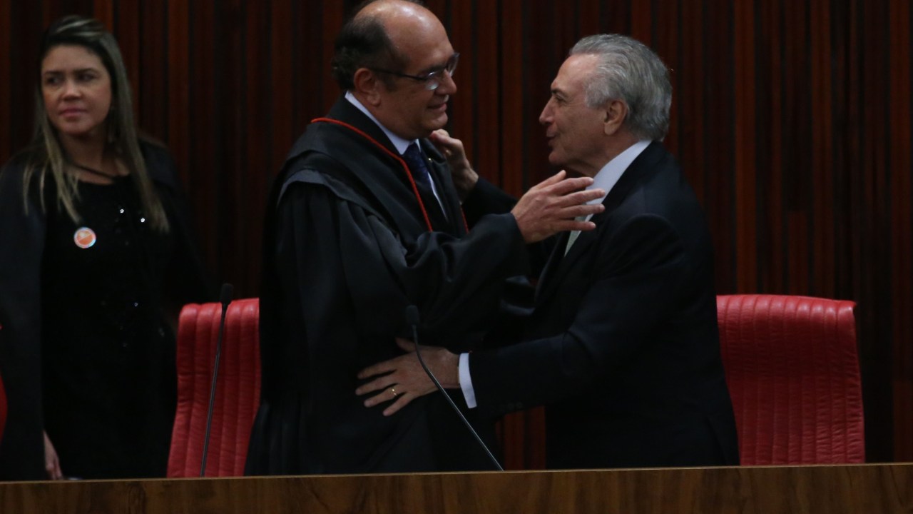 Gilmar Mendes abraça Michel Temer durante cerimônia no TSE