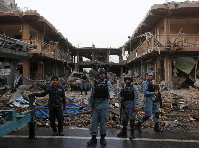 Policiais afegãos ficam de guarda no local de um ataque com um caminhão-bomba em Cabul, no Afeganistão
