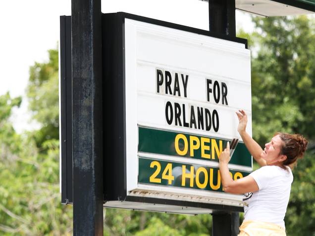 Empregada de uma rede de restaurantes fast-food, coloca os dizeres Reze por Orlando (tradução livre), em sua fachada, como mensagem de apoio às vítimas do massacre na boate Pulse, em Orlando, Flórida (EUA) - 12/06/2016