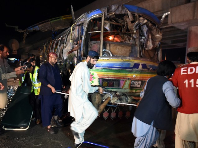 Voluntários e residentes retiram o corpo de uma das vítimas de um atentado a bomba a um ônibus na cidade de Quetta, no Paquistão - 19/10/2015