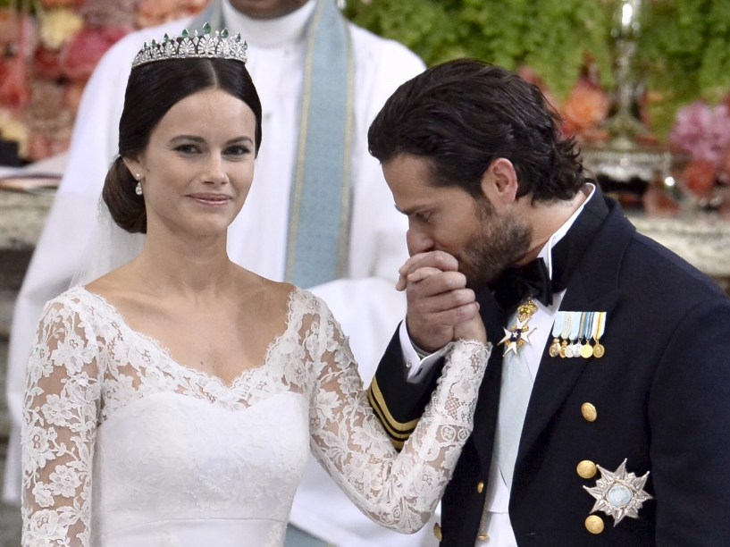 Príncipe sueco Carl Philip beija a mão de Sofia Hellqvist durante a troca de votos e anéis em seu casamento na Capela Real do Palácio de Estocolmo
