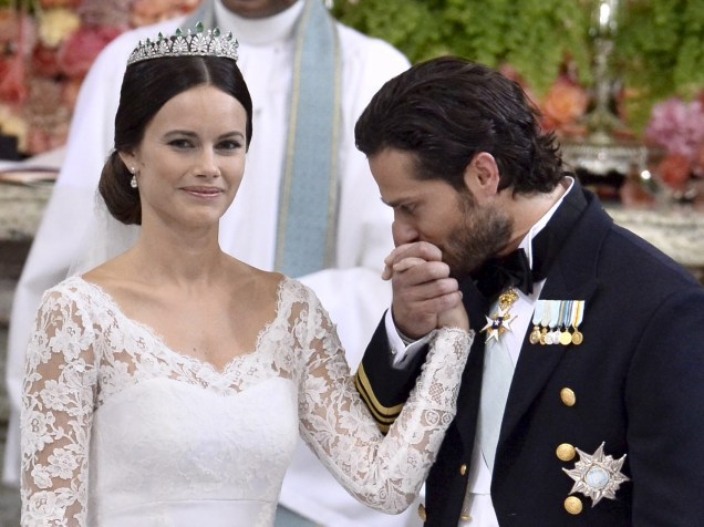 Príncipe sueco Carl Philip beija a mão de Sofia Hellqvist durante a troca de votos e anéis em seu casamento na Capela Real do Palácio de Estocolmo