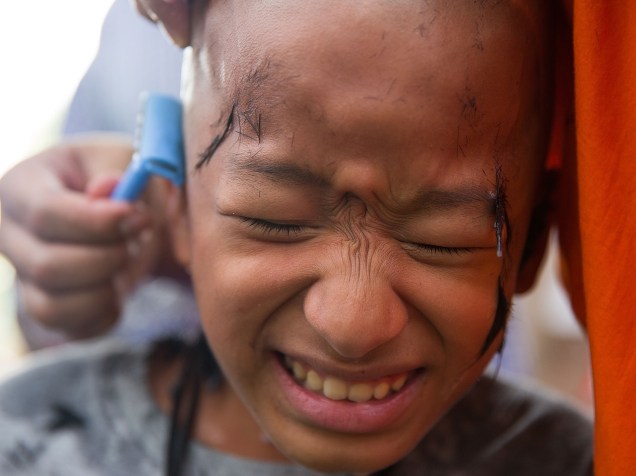 Menino tailandês tem sua cabeça raspada durante o festival Poy Sang Long. Garotos de 7 e 14 anos são iniciados nas doutrinas budistas durante a cerimônia - 01/04/2015