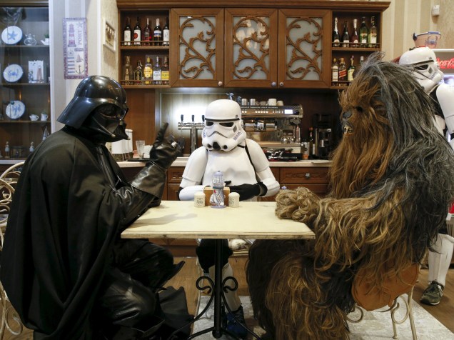 O ucraniano Darth Mykolaiovych Vader toma café durante momento de descontração com pessoas vestidas como Chewbacca e um Stormtrooper personagens da saga Star Wars