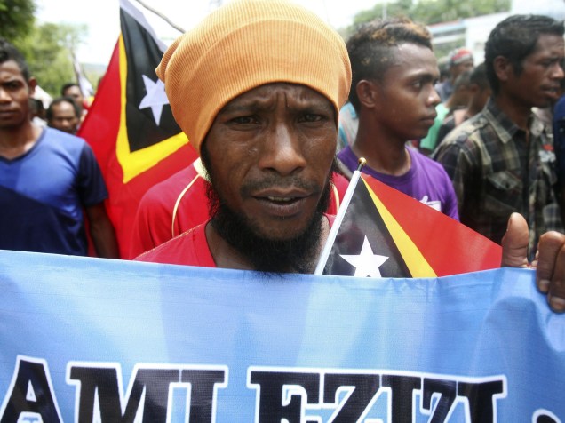 Homem segura cartaz durante protesto na cidade de Díli, no Timor-Leste, pelo dia internacional dos Direitos Humanos