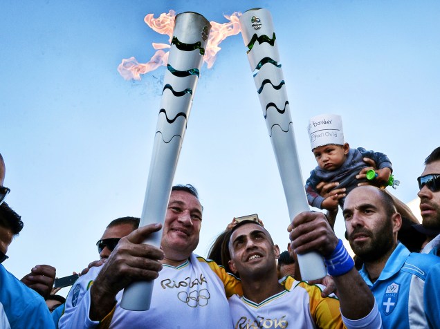 O presidente do comitê olímpico grego, Spyros Kapralos, e um refugiado sírio, revezam a tocha olímpica dos Jogos Rio-2016, no campo de refugiados em Eleona, na Grécia - 26/04/2016
