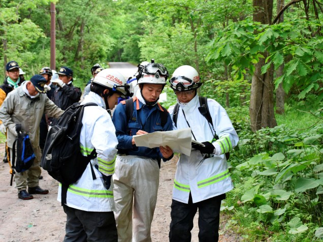 Equipes de emergência e voluntários procuram um menino de sete anos desaparecido na cidade Nanae no extremo norte da ilha principal de Hokkaido, no Japão - 30/05/2016