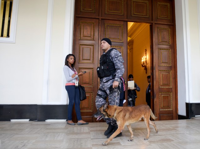 Um membro do Serviço de Inteligência Bolivariana anda com um cão por um corredor da Assembleia Nacional em Caracas. Três bombas panfletárias explodiram nos arredores do local sem deixar vítimas - 26/01/2016