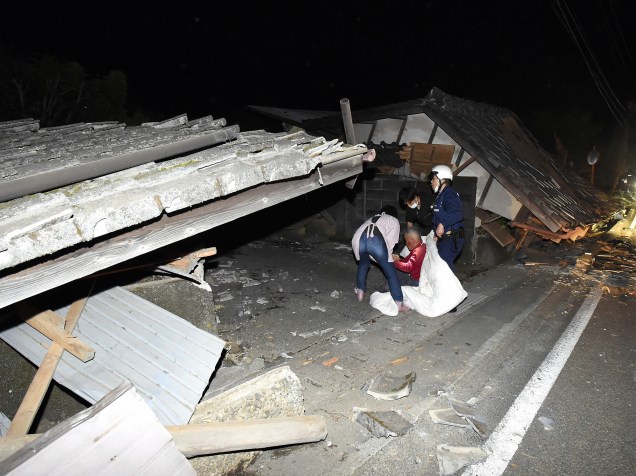 Moradores são retirados de suas casas, por equipes de resgate, após terremoto atingir a cidade de Kumamoto, sul do Japão - 14/04/2016