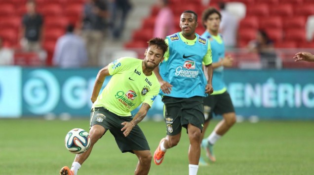 Neymar e Robinho durante treinamento em Cingapura. Capitão da seleção sente dores, mas está confirmado contra o Japão