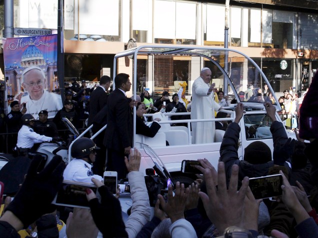 Mexicanos acenam na passagem de carro do papa Francisco na Cidade do México