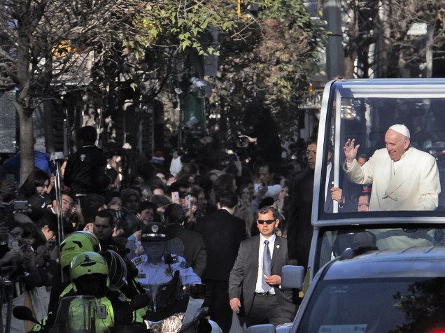 Mexicanos acenam na passagem de carro do papa Francisco na Cidade do México