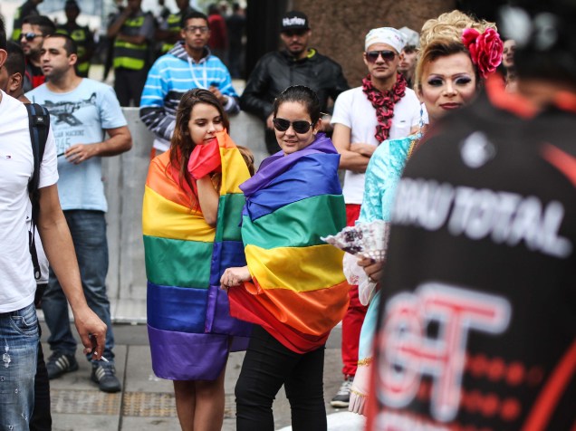 Meninas vestem bandeiras do orgulho LGBT, na Avenida Paulista